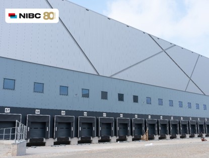 Het moderne, middelgrote magazijn met laadperrons 57 tot 62, onder een heldere lucht.