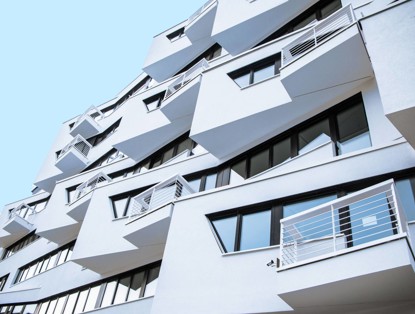 Moderne architectonische gevel met uitstekende balkons en grote ramen in een witte afwerking.